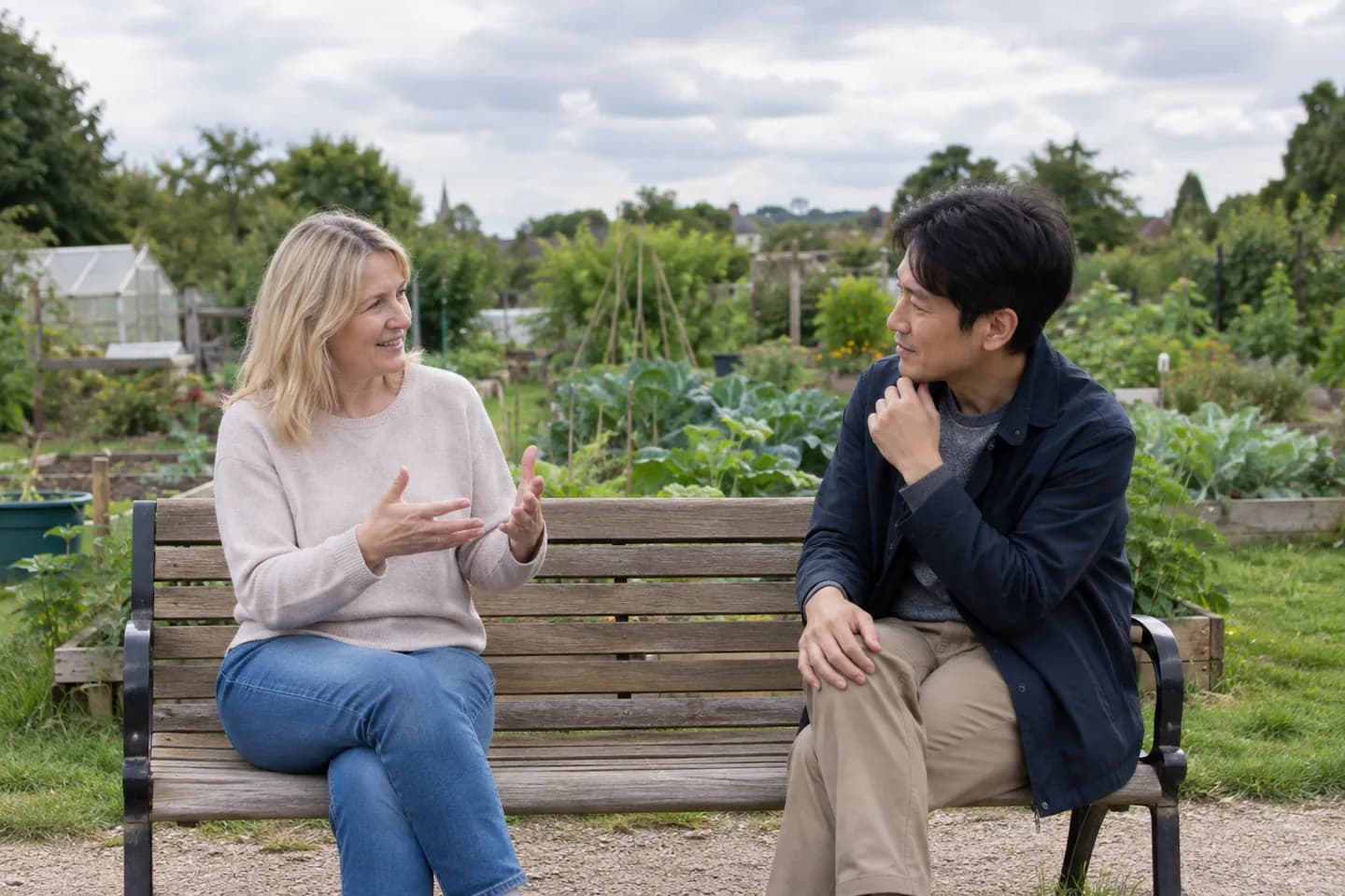 共同菜園のベンチでヨーロッパ人の女性と日本人の男性が会話を練習している