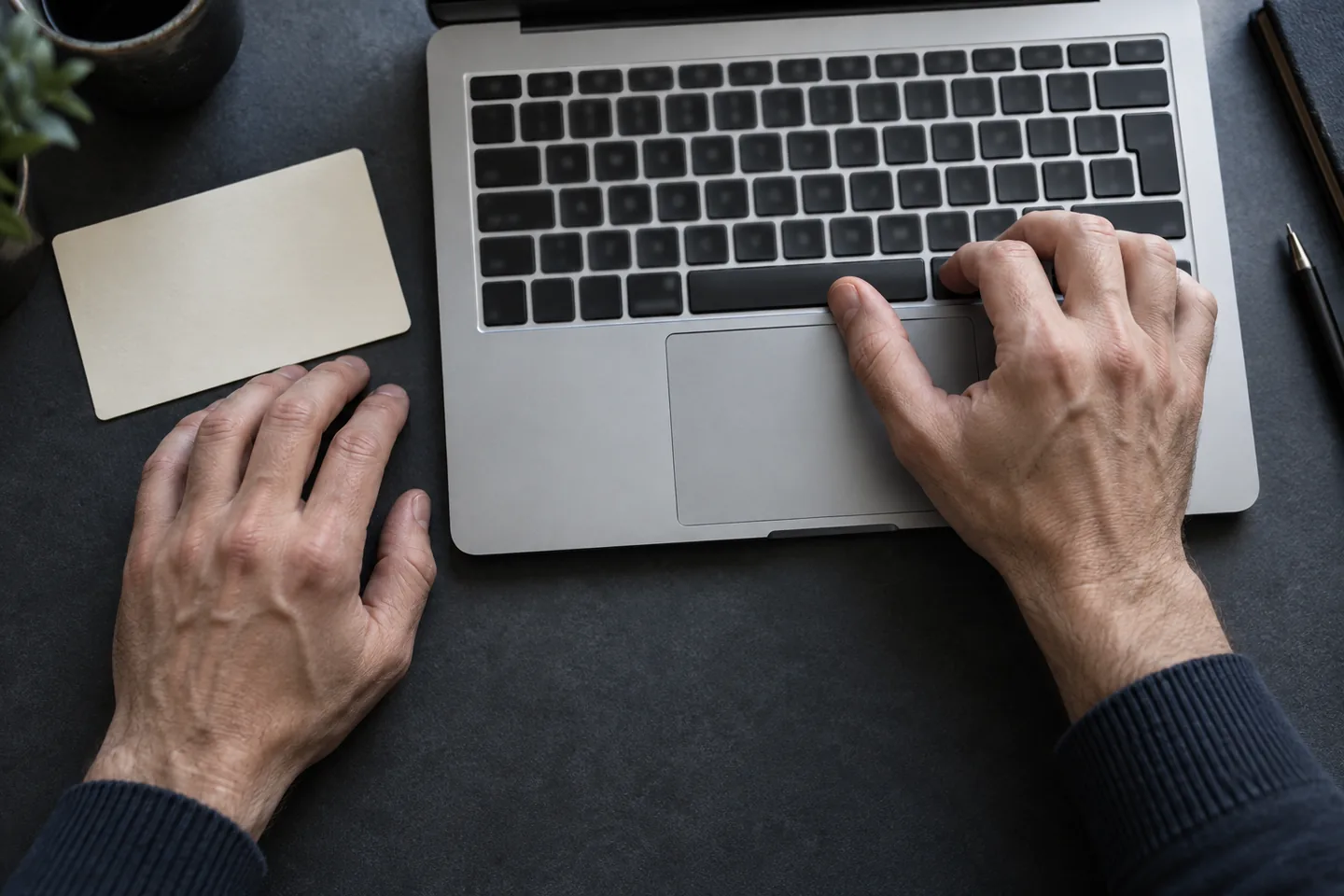 Hands practising at a laptop keyboard with a thumb near the spacebar
