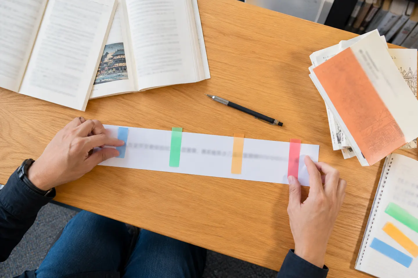 Adult hands separating a Japanese sentence into colored meaning groups with the final predicate clearly isolated